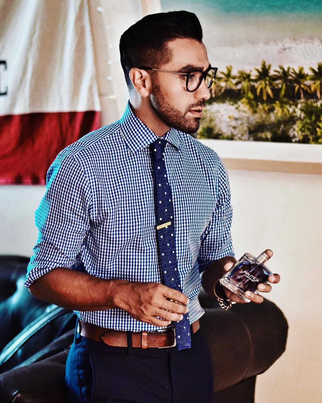 man holding a bottle of Nautica cologne