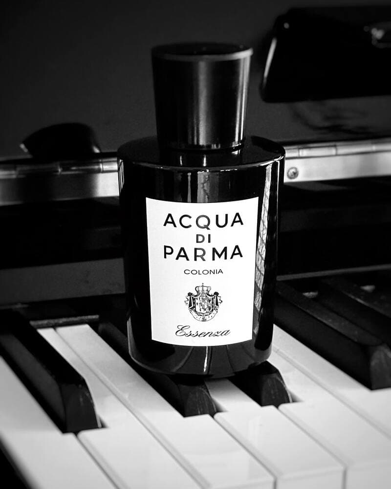 a bottle of Acqua Di Parma Essenza cologne on top of the piano keys