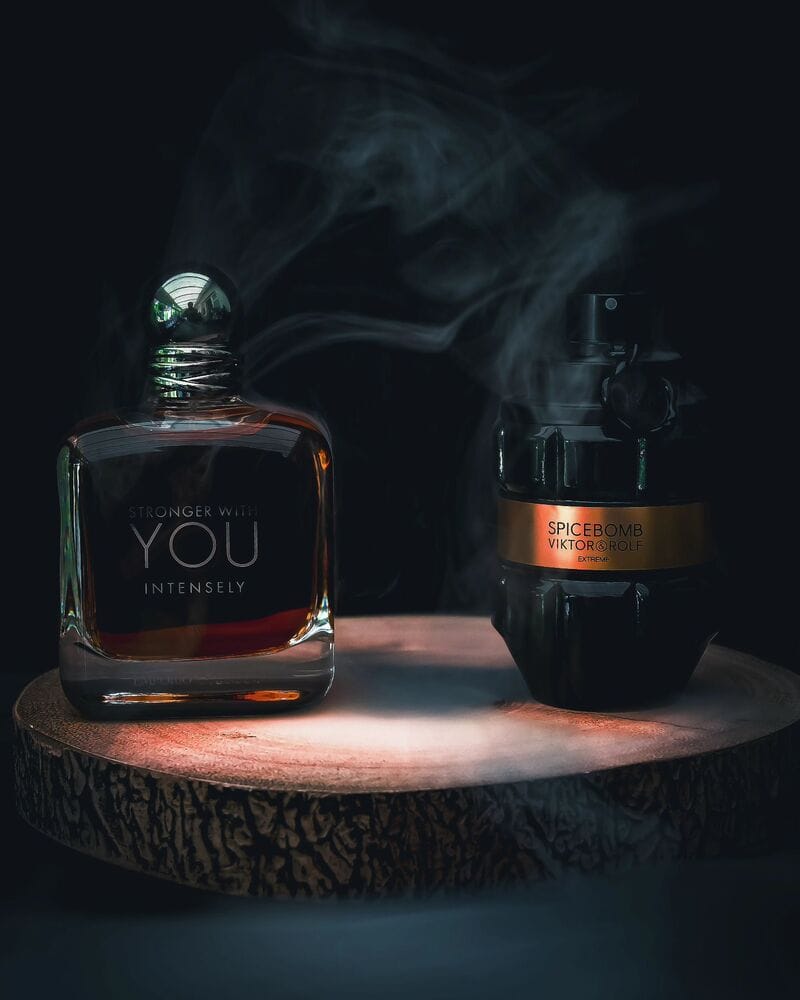 a bottle of Spice Bomb Extreme and Stronger with You Intensely colognes on a piece of wood