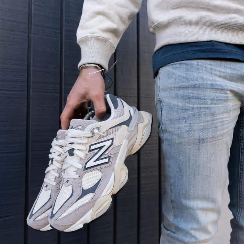 man carrying a pair of New Balance U9060 sneakers