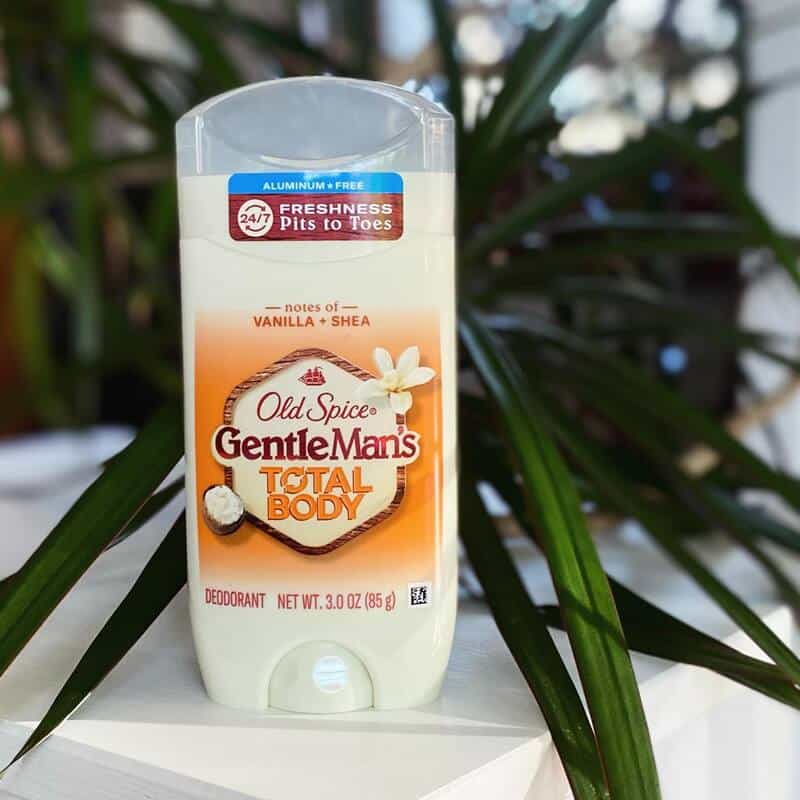 An old spice Whole body deodorant on top of a table with a plant as background