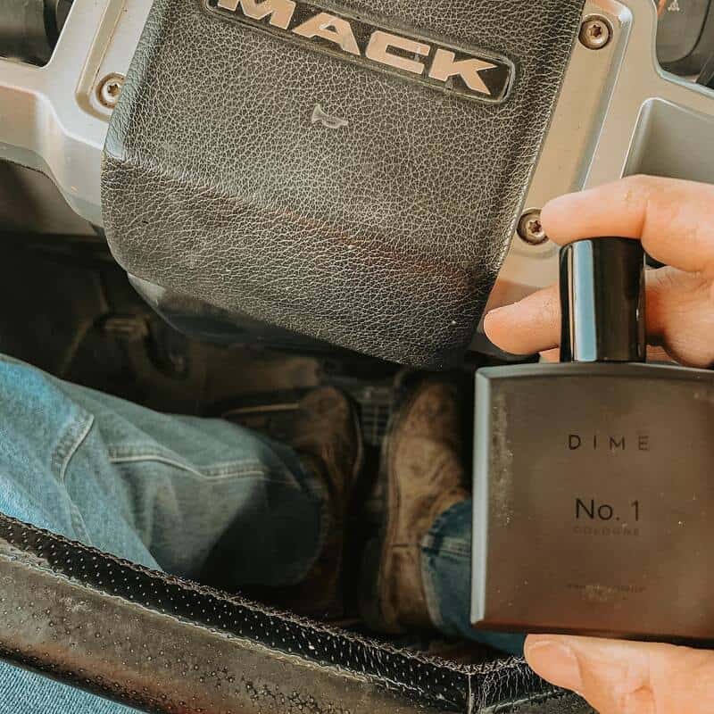 a truck driver holding a bottle of Dime No.1 Cologne