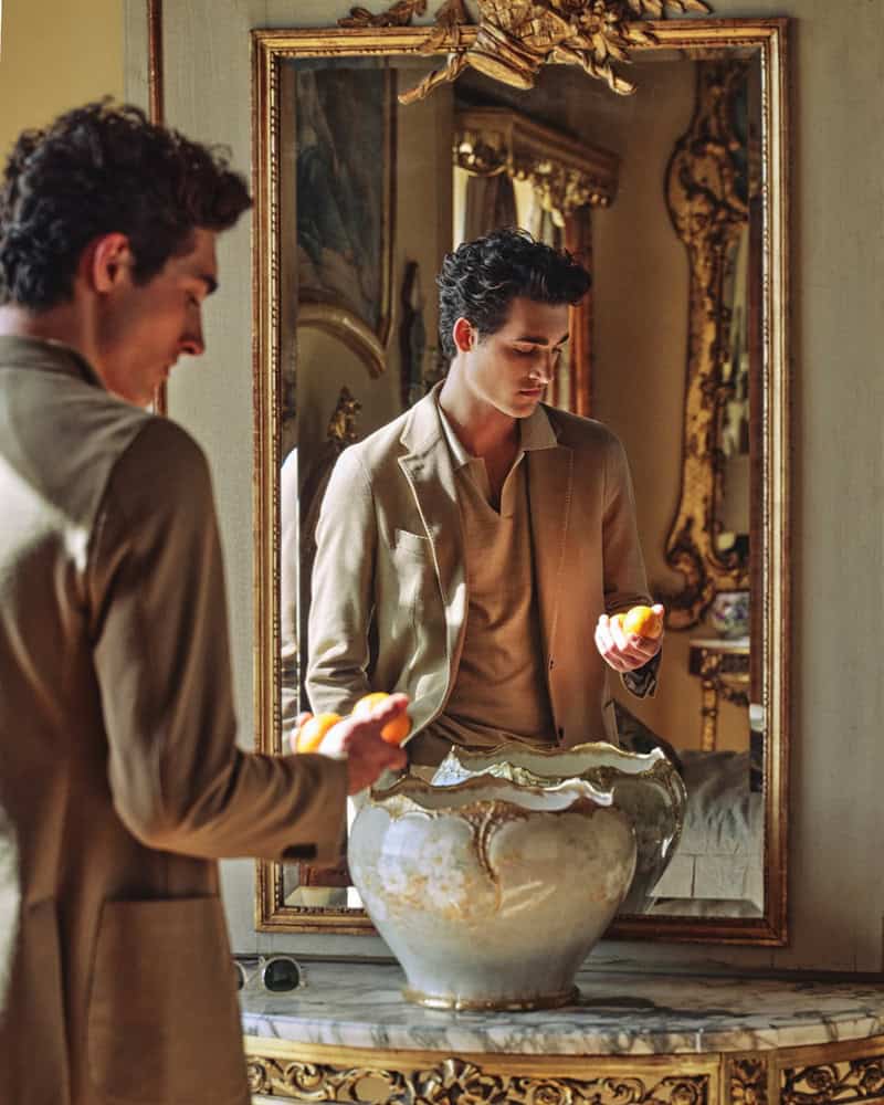 man in sports coat checking the fruit on his hand