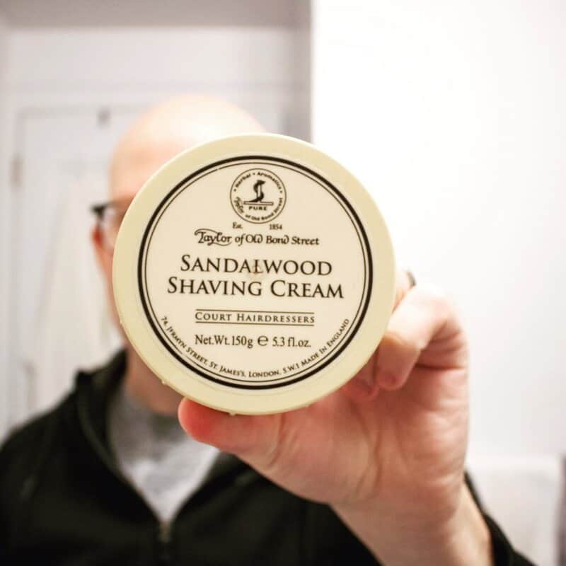 A man holding the Taylor of Old Bond Street Sandalwood Shaving cream
