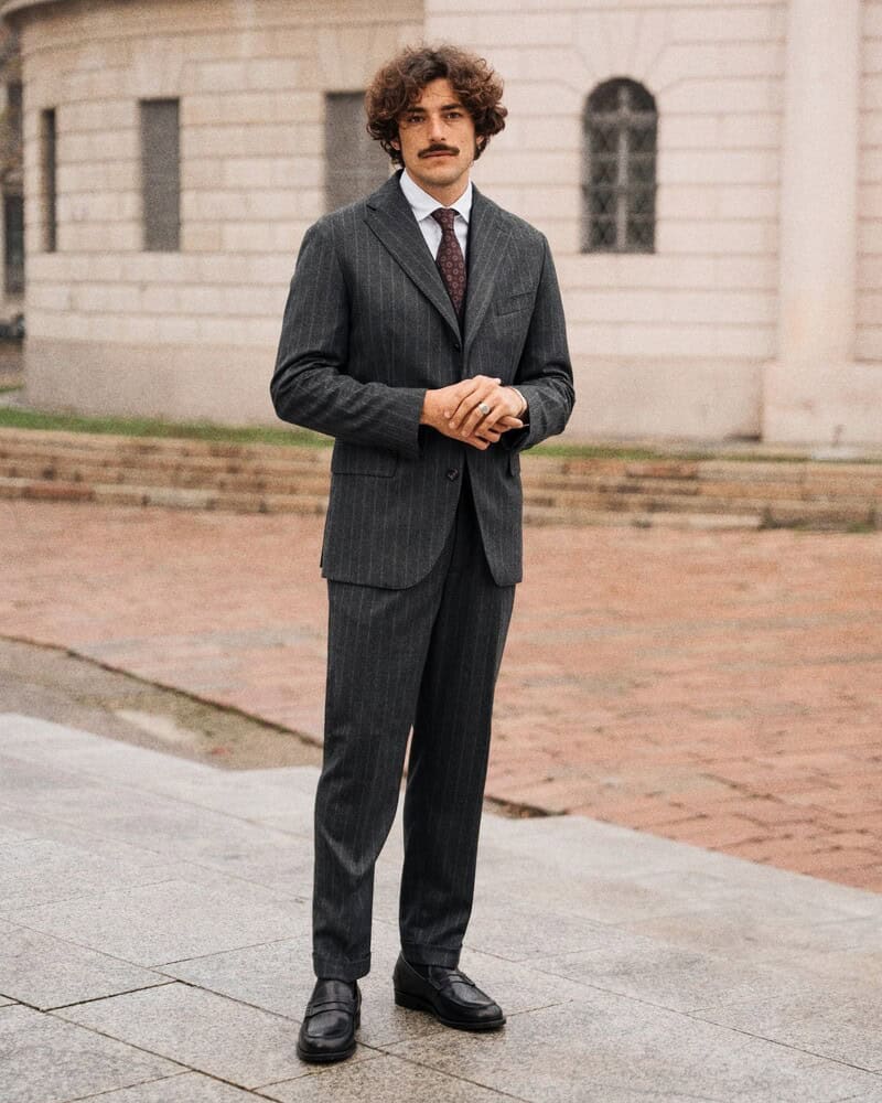 A man wearing a suit and a pair of velasca loafers
