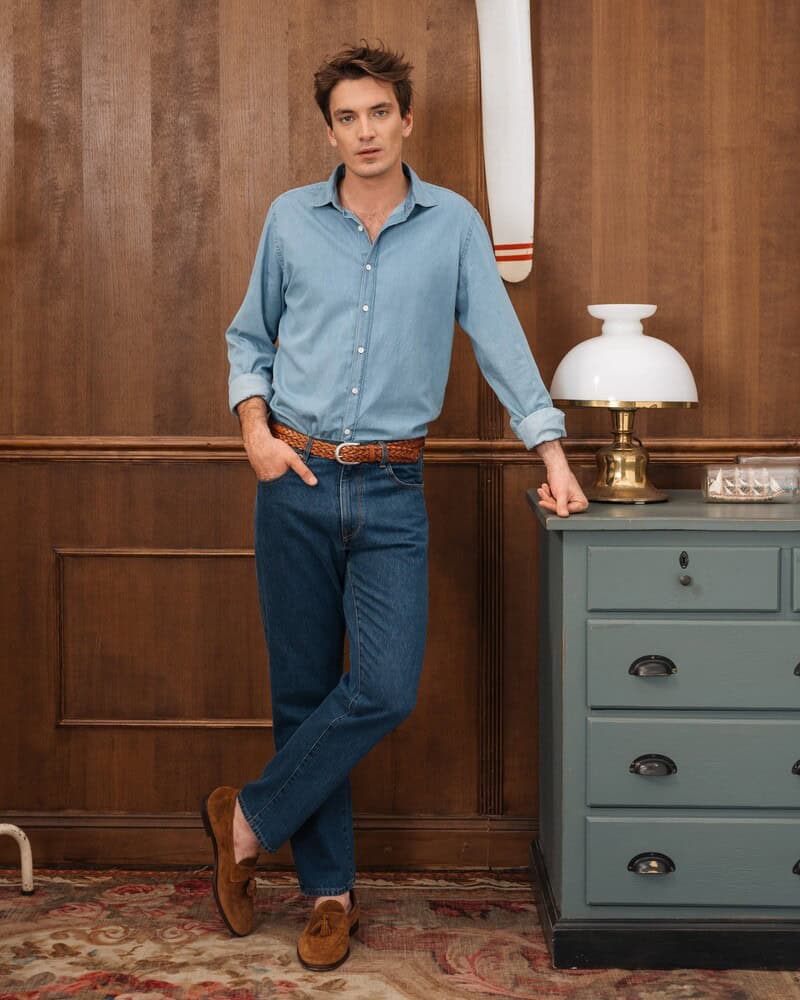 man wearing a velasca tassle loafers and sky blue shirt and denim