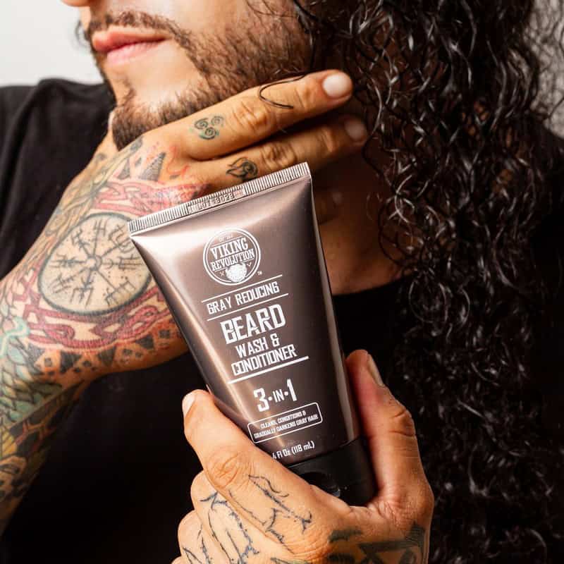 man holding a tube of Gray Reducing Beard Wash and Conditioner by Viking Revolution
