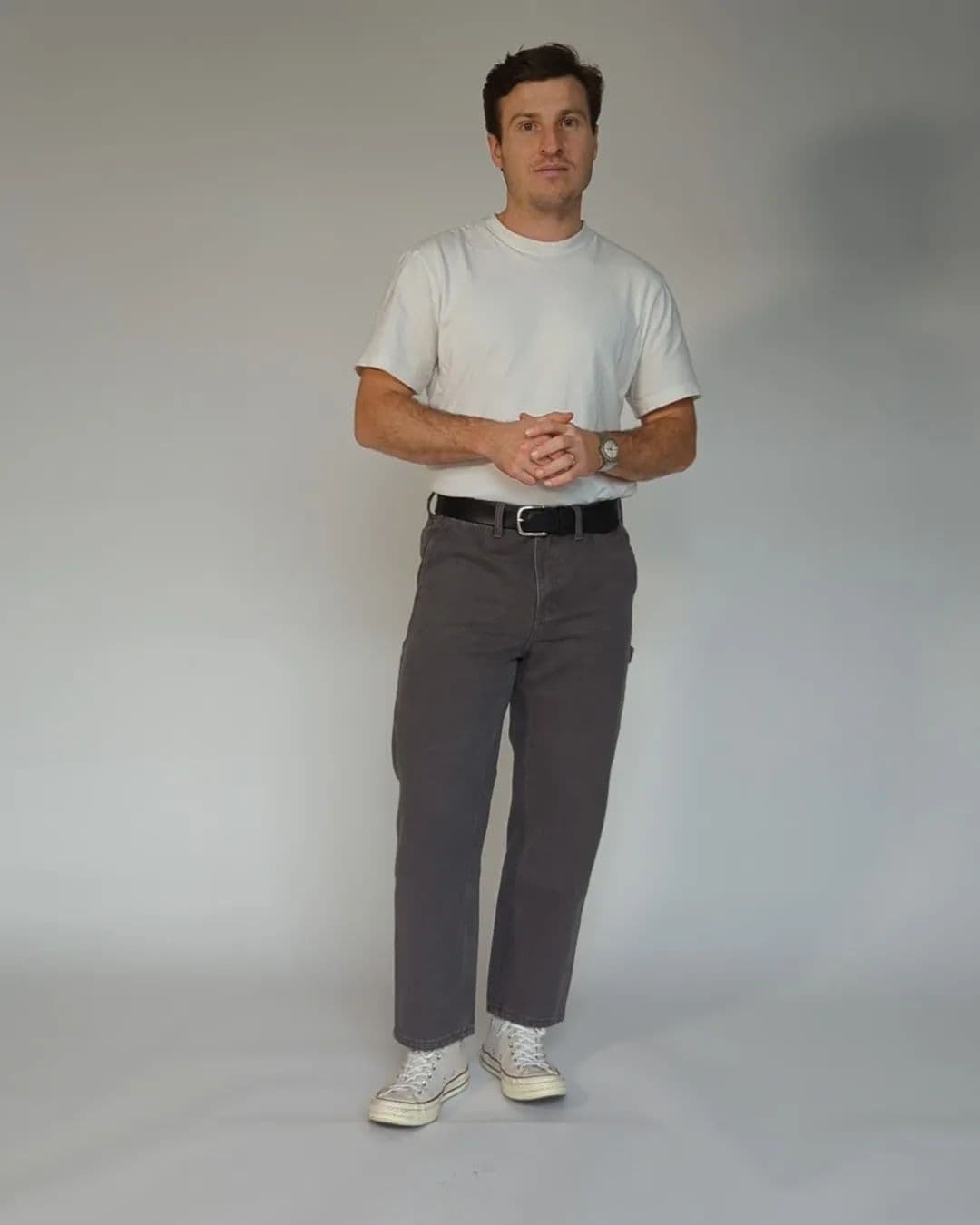 man wearing a white t-shirt and gray pants by abbreviated