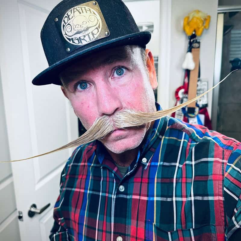 man with a Hungarian style mustache wearing a black hat