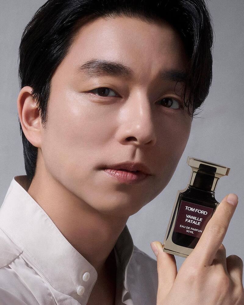 man holding a bottle of tom ford vanille fatale perfume