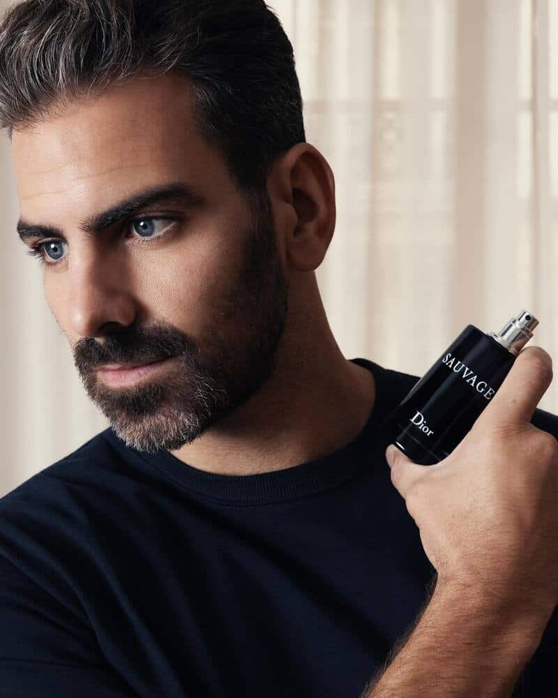 man holding a bottle of sauvage by dior