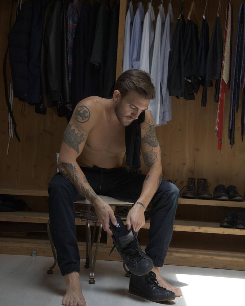 man inserting an insole into a high top sneaker