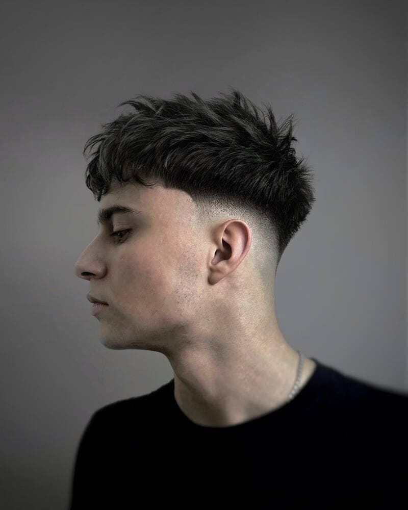man with textured crop haircut wearing a black t-shirt