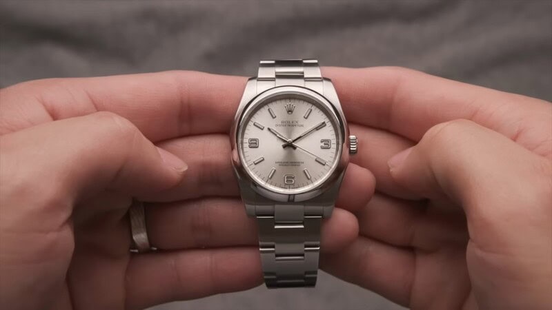 holding a Rolex Oyster Perpetual 116000