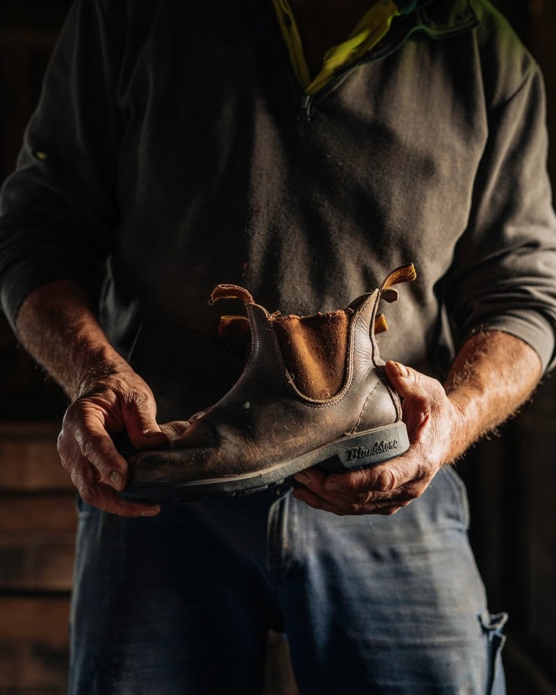 man holding a pair of Blundstone Boots