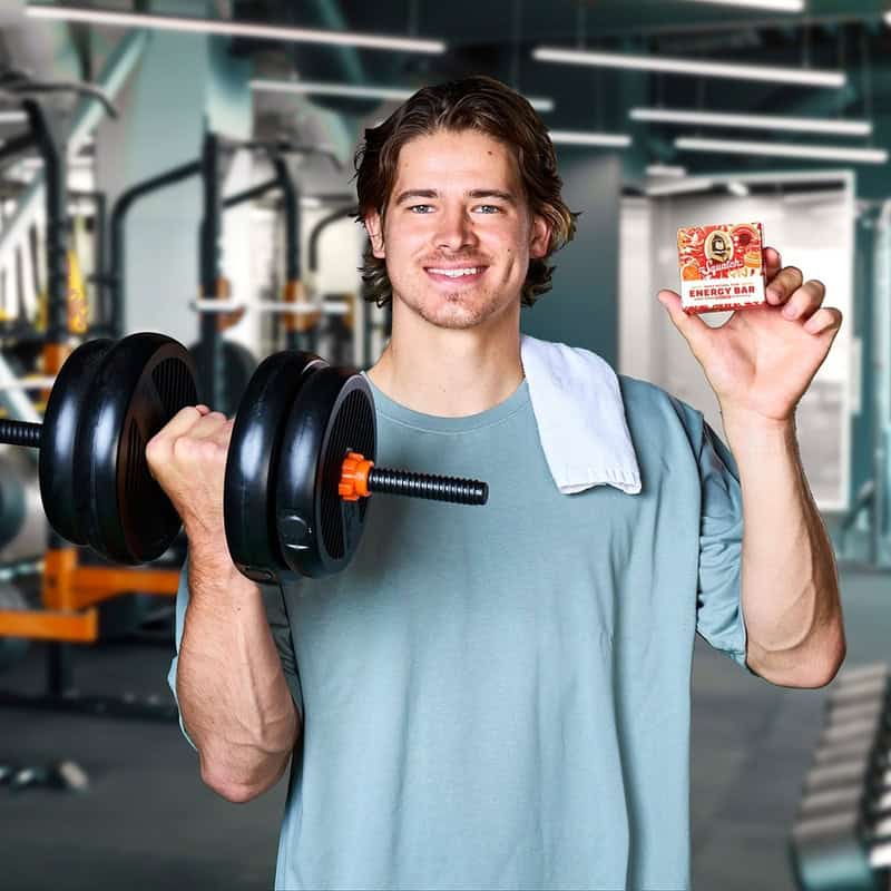 man carrying a dumbbell and holding The Dr Squatch Energy Bar Natural Soap