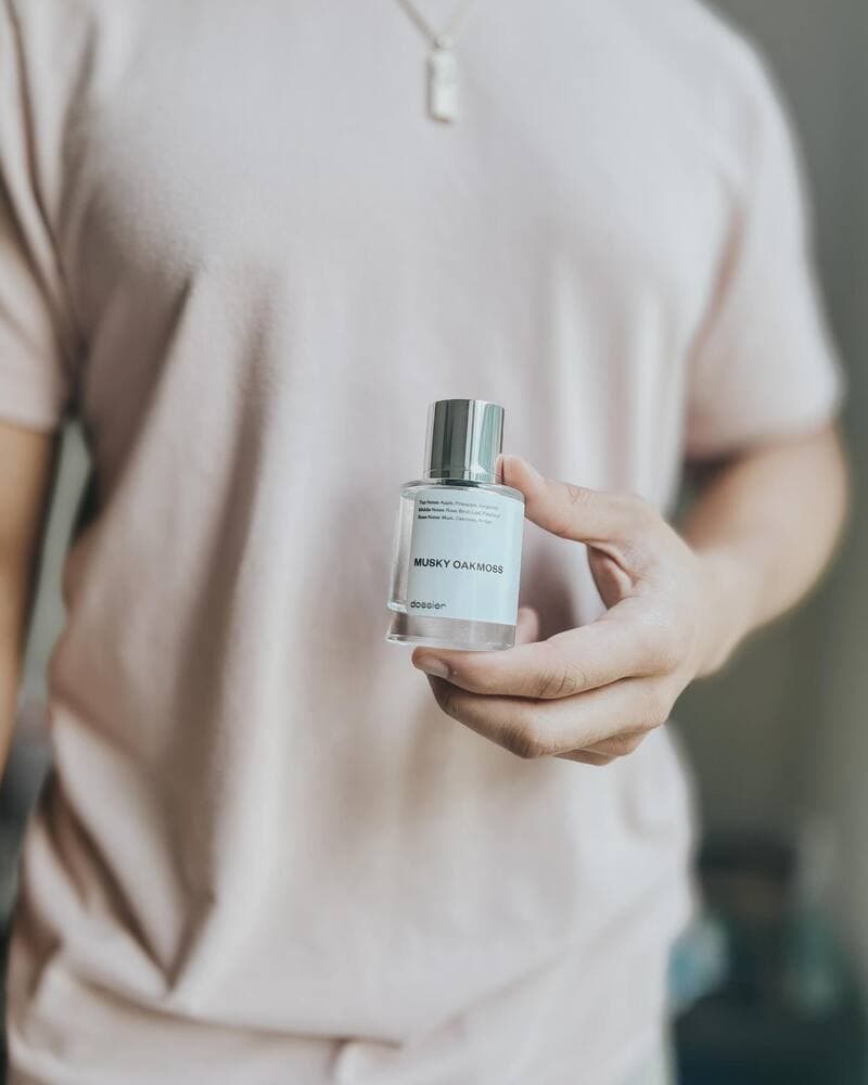 man holding a bottle of Musky Oakmoss perfume by Dossier