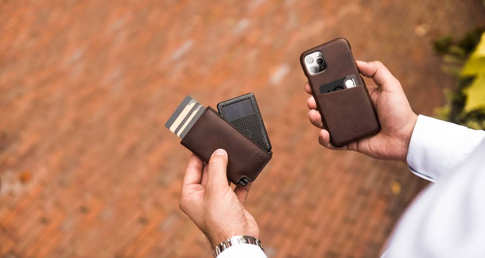 man holding a brown Ekster Wallet