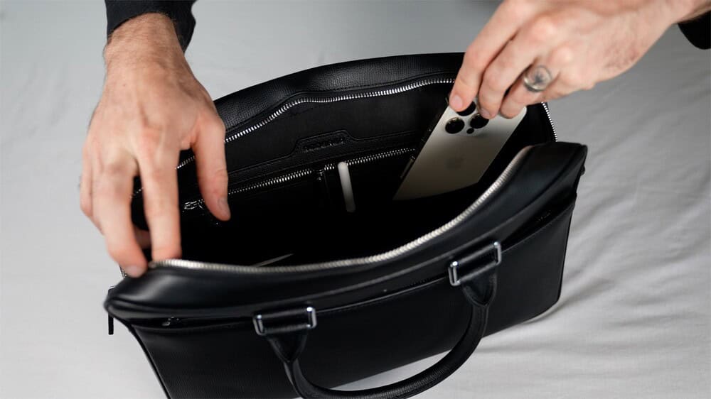 putting a phone in the pocket inside the briefcase