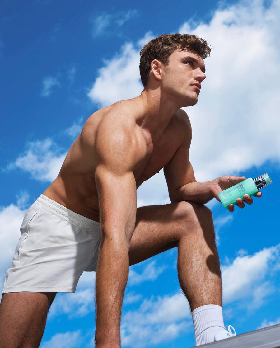 man in shorts is holding a bottle of Aquapower Advanced Gel by Biotherm