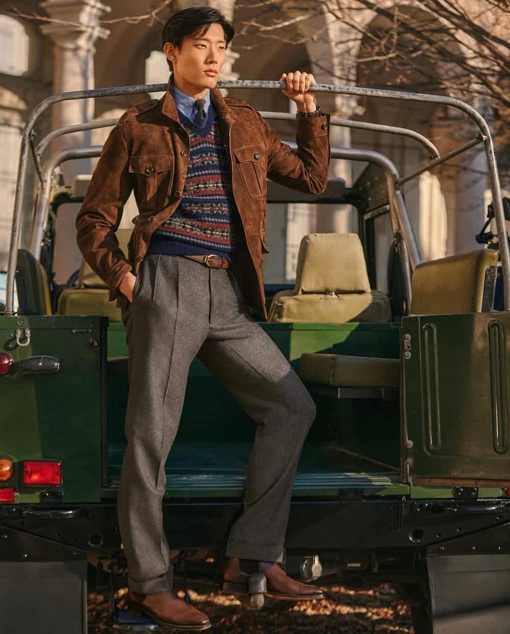 man standing at the back of a vehicle wearing a brown corduroy jacket