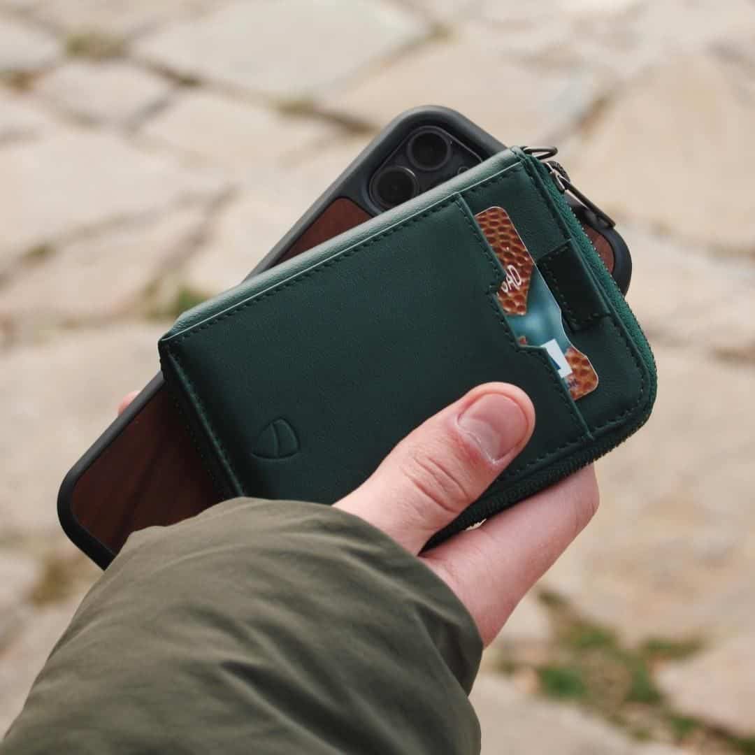 holding a phone and a Notting Hill wallet by Vaultskin