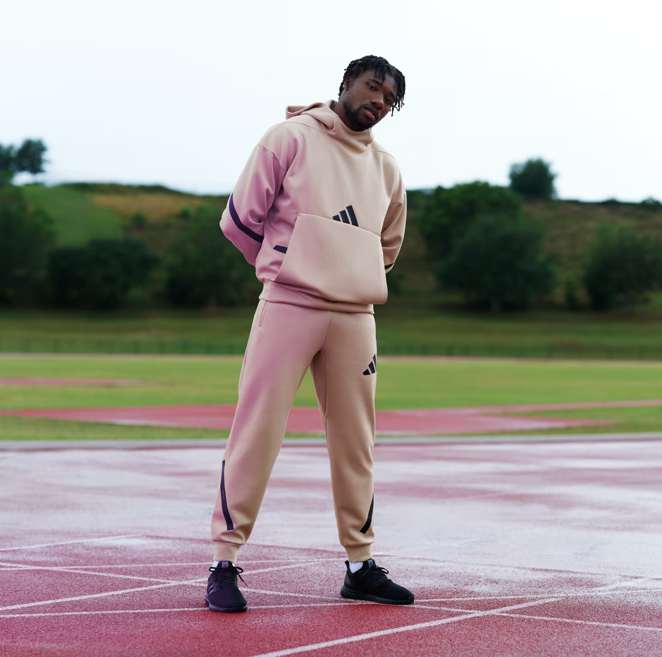 Stylish beige athletic hoodie and joggers with black accents, perfect for casual wear or sports activities, on a running track outdoors.