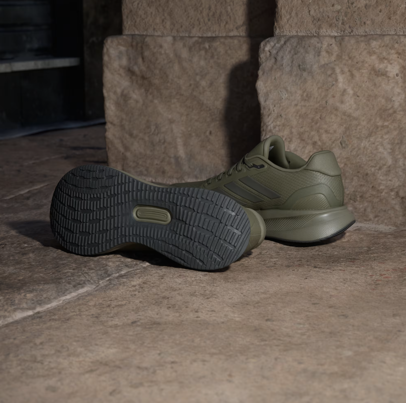 Comfortable olive green sneakers with durable rubber soles, perfect for casual and athletic wear, showcased on a rustic stone surface.